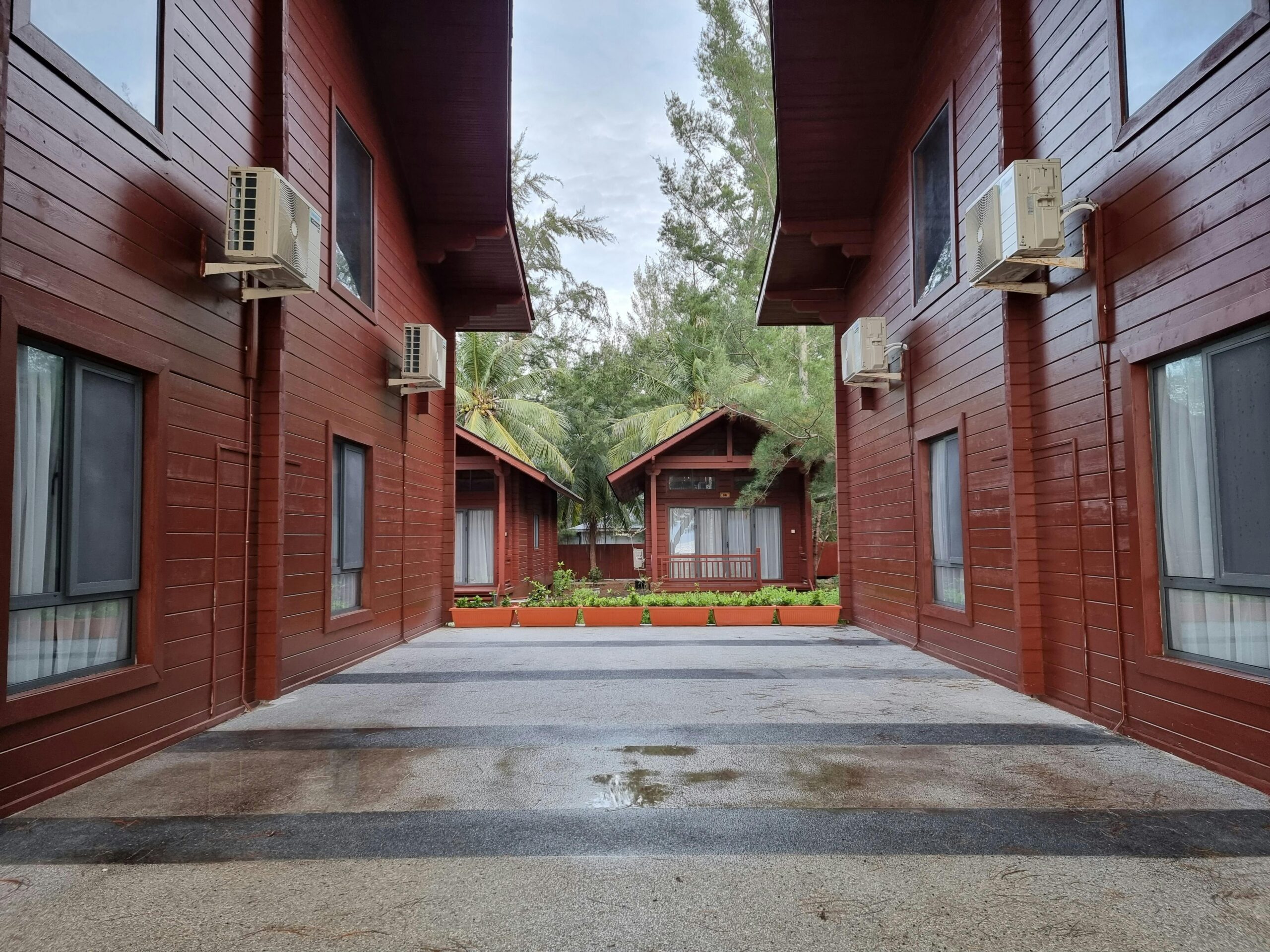 Wooden cabins with modern design surrounded by lush greenery and serene atmosphere.